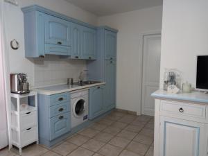 圣特奥多罗Appartamento Piano Terra Residence Geranium Beach的厨房配有蓝色橱柜和洗衣机。
