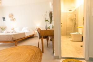 斯基亚索斯镇Dohos Skiathos Suites的一间卧室配有一张床、一张书桌和淋浴