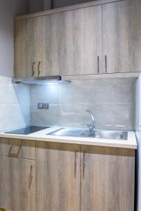 帕拉利亚潘塔利莫诺斯NikoleTakis Apartments的一个带水槽和木橱柜的厨房
