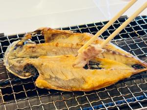 YoshihamaTHE RETREATMENT Yugawara的把一块食物放在一个有筷子的架子上
