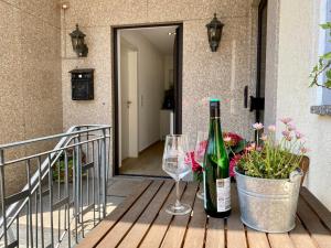 博恩海姆City Apartment in Bornheim - Köln Bonn Phantasialand的门廊上放一瓶葡萄酒和两杯酒