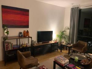墨西哥城Excelente departamento en la Condesa的客厅配有平面电视和椅子
