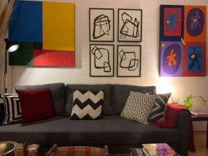 墨西哥城Excelente departamento en la Condesa的客厅配有灰色的沙发和一些图片