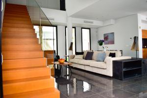 克萨达城Luxury Villa LAGUNA - Ciudad Quesada的带沙发和楼梯的客厅