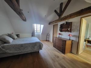 塔登Manoir de La Garaye - Suite Parentale的一间卧室配有一张床、一个梳妆台和一扇窗户。