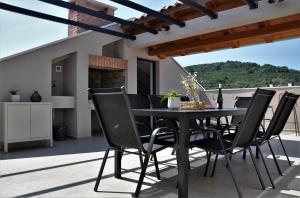 博扎瓦SOL luxury residence near the beach with shared heated pool的天井上的黑色餐桌和椅子