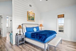 阿兰瑟斯港Luxury house with wet bar, outdoor shower, steps from Gulf的一间卧室设有蓝色的床和窗户。