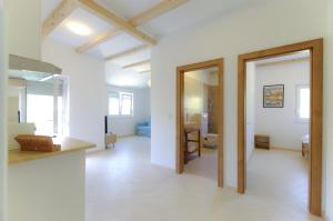 萨利Apartmani Porat Sali的开放式客厅拥有白色的墙壁和木梁。