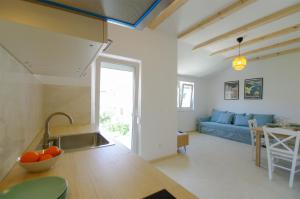 萨利Apartmani Porat Sali的厨房以及带蓝色沙发的客厅。