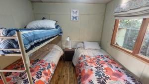 普孔Casa Camino al Volcán的小型客房设有两张双层床和窗户。