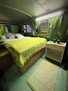 里加Urban Van Glamping Riga的卧室配有一张大床,位于货车后面