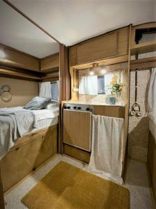 里加Urban Van Glamping Riga的一间卧室配有一张床,厨房配有炉灶