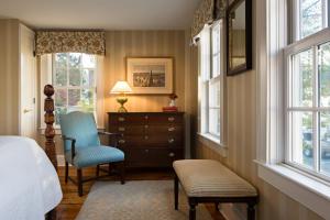 EssexThe Griswold Inn的一间卧室配有一张床、梳妆台和窗户。