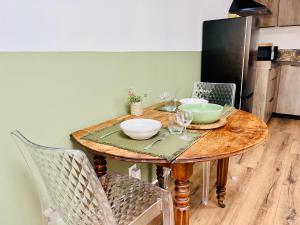 拉卡诺Le p'tit canaulais - Logement entier - rez de jardin - paisible的一张木桌,上面放着碗和酒杯