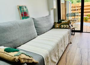 拉卡诺Le p'tit canaulais - Logement entier - rez de jardin - paisible的客厅里一张带毯子的灰色沙发