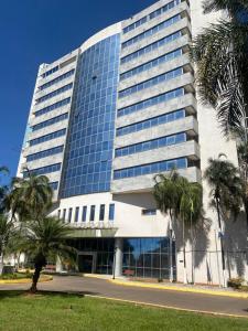 巴西利亚Promoção - Flat em Brasília的一座棕榈树环绕的大建筑