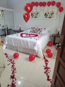 哈拉瓦科阿CASITA HOGAREÑA JARABACOA (independent entrance)的一间房间,地板上设有一张红色气球床和心。