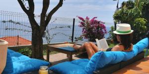 罗克布吕讷-卡普马丹Vue magnifique, piscine privée chauffée et sauna à 10min de Monaco的坐在沙发上读书的女人