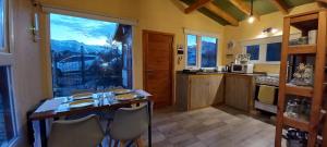 圣卡洛斯-德巴里洛切Casa con hermosa vista a los cerros的厨房配有桌椅和大窗户