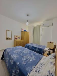 卢克索Luxor Rose Villa的一间卧室配有两张带蓝白色床单的床