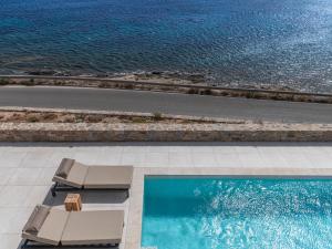 奥诺斯Myko Villa by Bestofmikonos的一个带2把躺椅的游泳池和海洋