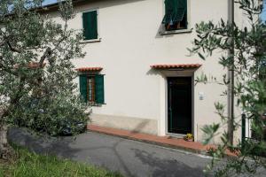 卡尔米尼亚诺多纳蒂纳达旅馆的白色的房子,有黑色的门和绿色百叶窗