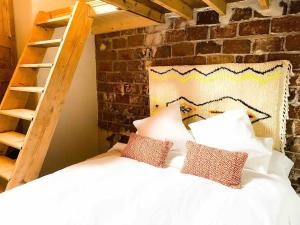 阿格特Casa Piedra Agaete的卧室配有带枕头和梯子的白色床。