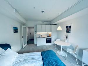 斯沃尔韦尔Lofoten Studio Penthouse的一间卧室配有一张床铺和一张桌子,还设有一间厨房