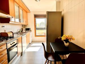 里斯本Sweety Bela Vista Apartment的厨房配有黑桌和黑冰箱。