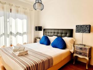 里斯本Sweety Bela Vista Apartment的一间卧室配有一张带蓝色枕头的大床