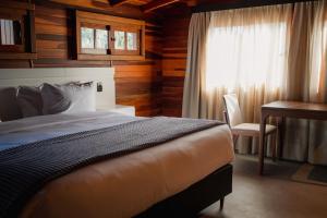 格拉玛多249 DESIGN HOTEL的一间卧室配有一张床、一张书桌和一个窗户。