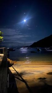 Praia VermelhaPousada e Mergulho Dolce Vita的夜晚在水体上满月