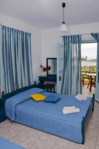普拉蒂Hotel Dina - Ξενοδοχείο Ντινα的一间享有海景的卧室,配有一张蓝色的床