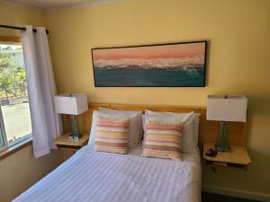 圣克鲁兹Sunny Cove Motel的一间卧室配有一张带两盏灯的床和一扇窗户。