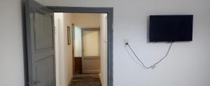 图努扬Casa de Julia的一间有门的房间,墙上有一台电视机