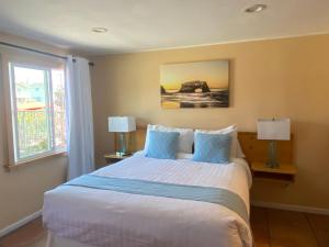 圣克鲁兹Sunny Cove Motel的一间卧室配有一张带两盏灯的床和一扇窗户。