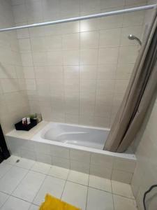 阿卜杜勒国王经济城شقة الاحلام的带淋浴的浴室内的白色浴缸