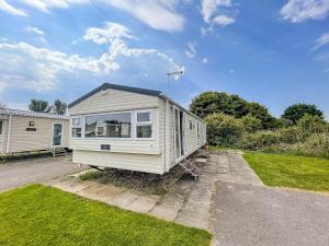 斯凯格内斯Homely 8 Berth Caravan In Southview Holiday Park, Ref 33048tc的停在院子里的白色小房子