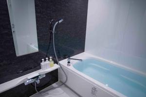 东京Shinjuku Miyabi Residence - Vacation STAY 94836的一间带浴缸和镜子的浴室