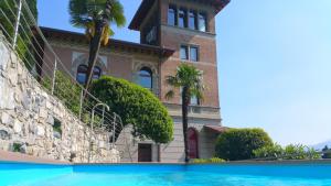 瓦伦纳蒙蒂别墅公寓的一座棕榈树环绕的建筑,位于游泳池前