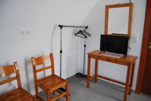 佩里萨阿波罗客房旅馆的客房设有一张桌子、一台电脑和一把椅子