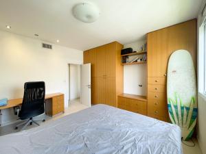 特拉维夫Spacious cosy & renovated flat in central Tel Aviv的一间卧室配有一张床和一个冲浪板