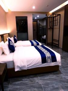 西哈努克东方酒店的一间卧室配有两张带蓝白色床单的床