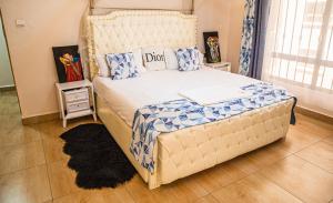 纳库鲁The Fancy Luxurious 3 bedroom apartment的一间卧室配有一张带蓝白色枕头的大床