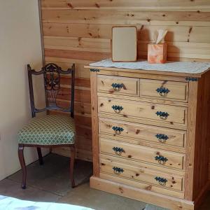 赫里福德Beautiful 1-Bed Lodge in Clifford Hereford的木制梳妆台,配有椅子和镜子
