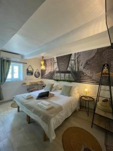 圣拉斐尔Hôtel Auberge Provençale的卧室配有一张大床,墙上挂有绘画作品