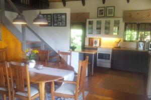 安德伯格The Underberg Cottage的厨房以及带桌椅的用餐室。