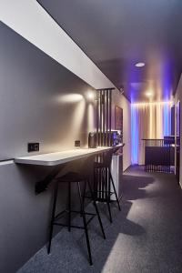 敖德萨Ultramarinn Hotel的紫色灯室里带凳子的酒吧