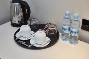 敖德萨Ultramarinn Hotel的桌子,盘子上装有杯子和瓶装水