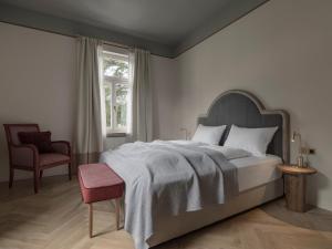 梅拉诺Villa Helvetia的卧室配有床、椅子和窗户。
